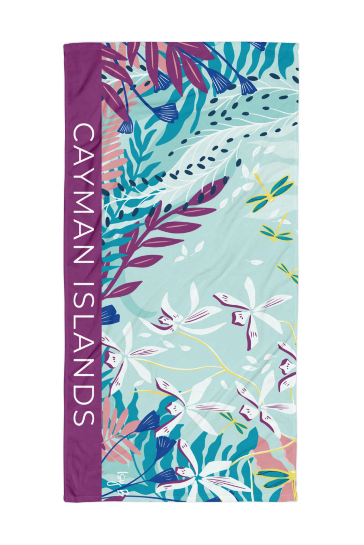 A rectangular beach towel featuring a tropical floral print with the words 'CAYMAN ISLANDS' printed vertically in white on a purple side panel, set against a plain white background.