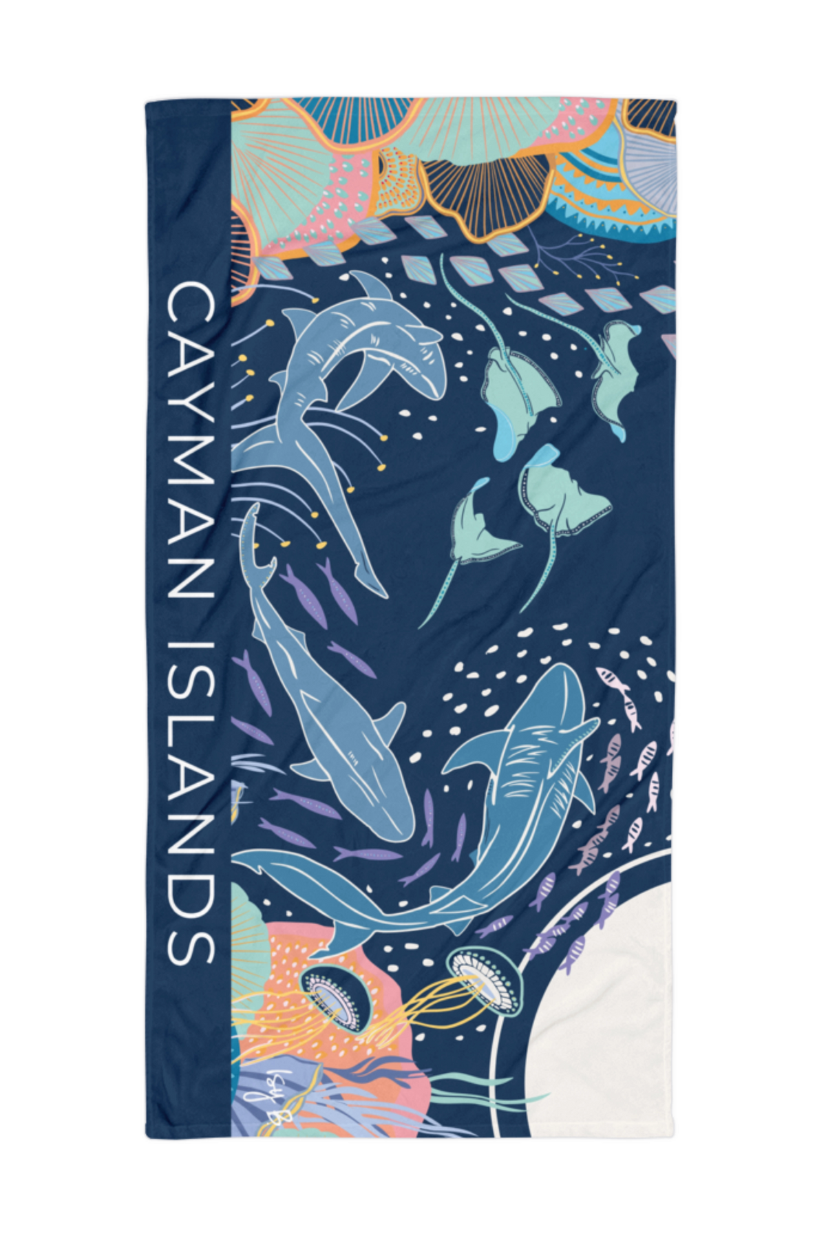 A rectangular beach towel featuring a colorful undersea design with sharks, jellyfish, and coral, plus the text 'CAYMAN ISLANDS' printed vertically on the left side.
